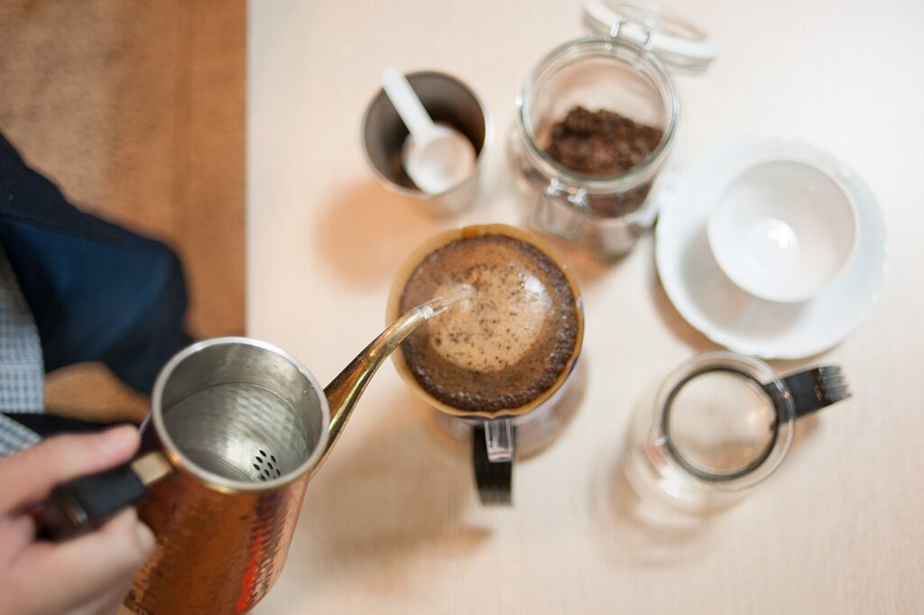 Hands pouring water over a pour-over coffee dripper